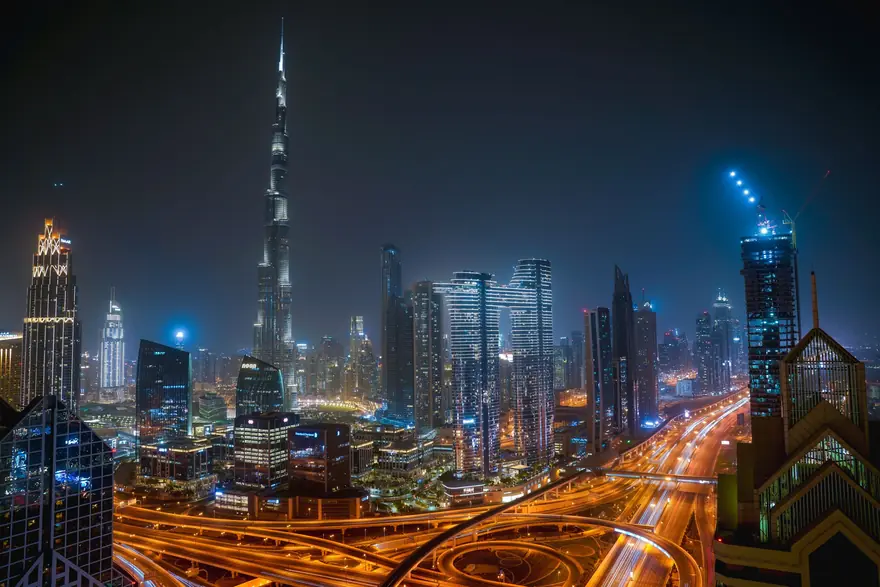 Dubai's Sheikh Zayed Road skyline at night with light trails on the highway