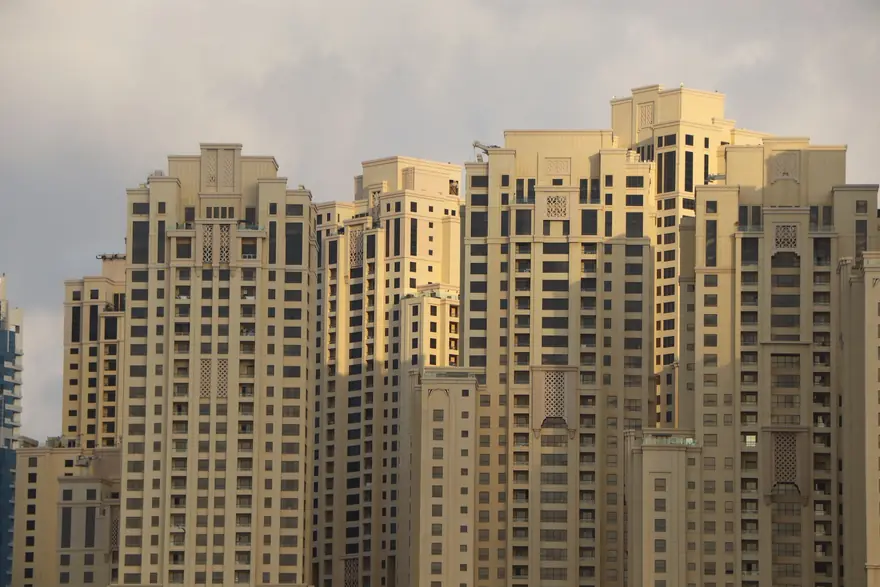 Sand coloured residential towers lit by the late afternoon sun