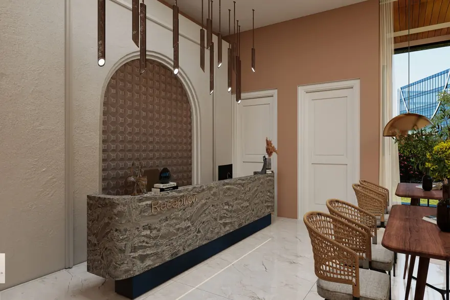 A reception desk with a carved stone front, arched wall and wicker chairs in a bright lobby