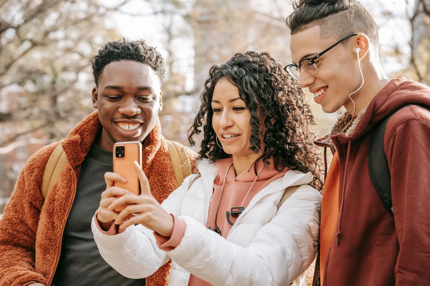 Three friends smiling at a phone together