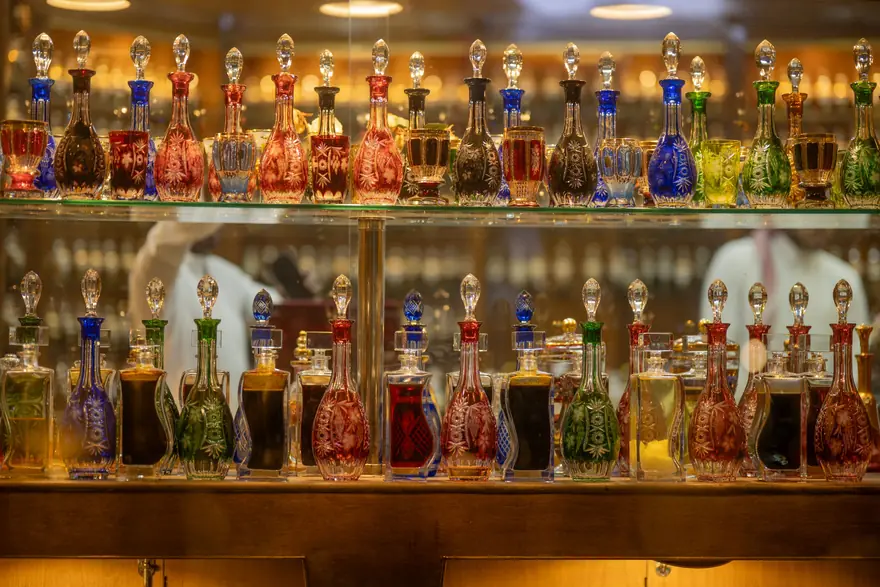 Shelves of ornate glass perfume and attar bottles in a fragrance shop